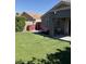 A spacious backyard featuring a covered patio, artificial turf, and a porch swing at 9726 E Butte St, Mesa, AZ 85207