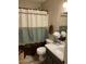 Bathroom with white vanity, toilet, and blue, white and brown shower curtain at 9726 E Butte St, Mesa, AZ 85207