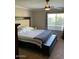 A well-lit bedroom with a large window and a comfortable queen-sized bed with a decorative headboard at 9726 E Butte St, Mesa, AZ 85207