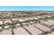Expansive aerial view showcasing a neighborhood with tile-roofed homes and mountain views against a clear blue sky at 10029 E Wavelength Ave, Mesa, AZ 85212