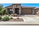 Inviting single-story house showcasing stone details, a 2-car garage, and desert-style landscaping at 10029 E Wavelength Ave, Mesa, AZ 85212