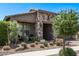 Attractive single-story house featuring stone accents, a 2-car garage, and well-maintained desert landscaping at 10029 E Wavelength Ave, Mesa, AZ 85212