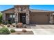 Charming single-story home featuring a stone facade, tile roof, and well-maintained landscaping at 10029 E Wavelength Ave, Mesa, AZ 85212