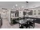 Well-lit kitchen and dining area featuring dark cabinets, stainless steel appliances, and a spacious island at 10029 E Wavelength Ave, Mesa, AZ 85212
