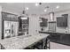 Modern kitchen with dark cabinets, stainless steel appliances, a large island, and pendant lighting at 10029 E Wavelength Ave, Mesa, AZ 85212