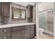 Bathroom featuring a granite countertop, vanity, a tiled shower, and neutral wall paint at 10244 N 65Th Ln, Glendale, AZ 85302