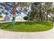Well maintained dog park with lush green grass, mature shade trees, and a pet waste station under a blue sky at 10244 N 65Th Ln, Glendale, AZ 85302