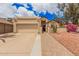 Tan home showcasing a two-car garage, gated entry, with low maintenance desert landscaping at 10244 N 65Th Ln, Glendale, AZ 85302