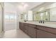 Modern bathroom featuring a double vanity, quartz countertop, and a sleek glass-enclosed shower at 10332 E Utah Ave, Mesa, AZ 85212