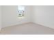 Well-lit bedroom with neutral carpet and a window overlooking a street at 10332 E Utah Ave, Mesa, AZ 85212