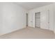 Bright bedroom with neutral carpet, white walls, and a closet with double doors at 10332 E Utah Ave, Mesa, AZ 85212