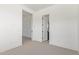 Bright bedroom with neutral carpet and white walls, showcasing doorways to other rooms at 10332 E Utah Ave, Mesa, AZ 85212