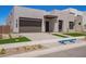 Modern home featuring desert landscaping, a gray two-car garage, and a geometric walkway at 10332 E Utah Ave, Mesa, AZ 85212