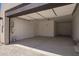 Spacious, well-lit garage with an open door, showcasing ample parking and storage potential with bright white walls at 10332 E Utah Ave, Mesa, AZ 85212