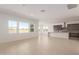 Open-concept living room featuring bright white walls and tile floors. Also, an adjacent kitchen at 10332 E Utah Ave, Mesa, AZ 85212
