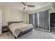 Cozy bedroom with neutral carpet, a ceiling fan, and a large window covered by dark curtains at 11156 E Lost Canyon Ct, Gold Canyon, AZ 85118