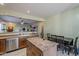 Well-lit kitchen with stainless steel appliances, wooden cabinets, an island, tile flooring, and a dining area at 11156 E Lost Canyon Ct, Gold Canyon, AZ 85118