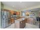 Bright kitchen with stainless steel appliances, wooden cabinets, an island, and tile flooring with an open design concept at 11156 E Lost Canyon Ct, Gold Canyon, AZ 85118