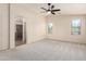 Bright bedroom with a ceiling fan and a doorway leading into a luxurious bathroom with glass enclosed shower at 11834 N 147Th Ln, Surprise, AZ 85379