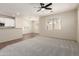 Open-concept living space featuring a partial kitchen view, bright natural light, and plush carpeting at 11834 N 147Th Ln, Surprise, AZ 85379