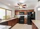 Kitchen boasts wood cabinets, granite countertops, and modern black appliances at 129 Leisure World --, Mesa, AZ 85206