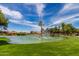 Scenic pond with a central fountain surrounded by lush greenery and community buildings at 129 Leisure World --, Mesa, AZ 85206
