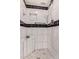 White tiled shower with black accent tiles, a tiled corner seat, and grab bar at 129 Leisure World --, Mesa, AZ 85206