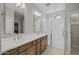 Bright bathroom featuring a double sink vanity, a large mirror, and glass enclosed shower at 13473 N 158Th Ave, Surprise, AZ 85379