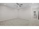 A neutral carpeted bedroom with a ceiling fan and a view into the hall through the arched entry at 13473 N 158Th Ave, Surprise, AZ 85379