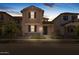 Dusk shot of charming two-story home with neutral stucco, landscaped front yard and covered entrance at 13473 N 158Th Ave, Surprise, AZ 85379