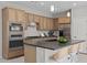 Bright kitchen featuring stainless steel appliances, breakfast bar, wood cabinets, and subway tile backsplash at 13473 N 158Th Ave, Surprise, AZ 85379