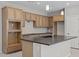 Well-lit kitchen featuring natural wood cabinetry, gray countertops, and stainless steel faucet at 13473 N 158Th Ave, Surprise, AZ 85379