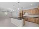 Spacious kitchen featuring a center island, wood cabinetry, and seamless flow into the dining area at 13473 N 158Th Ave, Surprise, AZ 85379