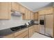 Well-equipped kitchen featuring stainless steel appliances, light wood cabinets, and dark countertops at 13473 N 158Th Ave, Surprise, AZ 85379