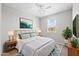 Stylish bedroom with a queen bed, a modern dresser, a ceiling fan, and lots of natural light at 13473 N 158Th Ave, Surprise, AZ 85379