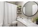 Bathroom features a modern vanity with marble countertop, round mirror, decorative shelving, and a shower with a white curtain at 14545 N 99Th St, Scottsdale, AZ 85260