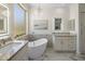 Luxurious bathroom with a soaking tub, vanity with stone countertop, an illuminated mirror, and a large window at 14545 N 99Th St, Scottsdale, AZ 85260