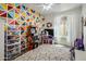 Colorful bedroom with vibrant geometric wall decor, an arcade game, and a bright, playful atmosphere at 14545 N 99Th St, Scottsdale, AZ 85260