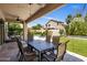 Covered patio with a dining table and chairs, overlooking the pool and landscaped backyard at 14545 N 99Th St, Scottsdale, AZ 85260