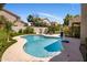 Backyard pool with blue water, surrounded by a patio, lush greenery, and mature landscaping at 14545 N 99Th St, Scottsdale, AZ 85260