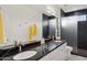 Modern bathroom featuring dual sinks, a large mirror, and a walk-in shower with black marble at 15045 E Sundown Dr, Fountain Hills, AZ 85268