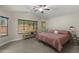 This bedroom features wood-look floors, a ceiling fan and a view of the back yard through the large windows at 1518 E 12Th St, Casa Grande, AZ 85122