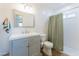 Bright bathroom features a vanity with gray cabinets, a framed mirror, and a shower with a neutral shower curtain at 1546 W Pierce St, Phoenix, AZ 85007