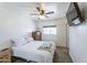 Bright bedroom featuring a comfortable bed, ceiling fan, and a dresser with a light-filled window at 1546 W Pierce St, Phoenix, AZ 85007