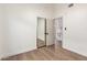 This bedroom has wood-style vinyl flooring, a mirrored closet, and a view to the kitchen at 1591 S Sycamore Pl, Chandler, AZ 85286