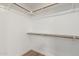 Spacious walk-in closet features natural wood rods, ample shelving, and vinyl flooring at 1591 S Sycamore Pl, Chandler, AZ 85286