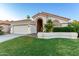 Beautiful home featuring a two-car garage, manicured lawn, and desert landscaping at 1591 S Sycamore Pl, Chandler, AZ 85286