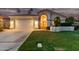 Stunning exterior view of home at dusk featuring a well-manicured lawn, a two-car garage, and lovely landscaping at 1591 S Sycamore Pl, Chandler, AZ 85286