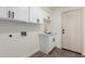 The laundry room features white cabinets with black hardware and vinyl plank flooring at 1591 S Sycamore Pl, Chandler, AZ 85286