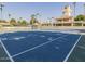 Tennis court with a well-maintained surface and nets, surrounded by mature trees and landscaping at 1591 S Sycamore Pl, Chandler, AZ 85286